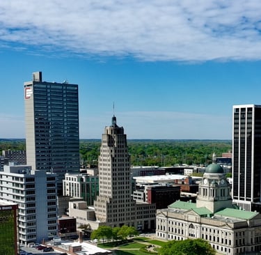 Aerial view of the Fort Wayne skyline featuring the Lincoln Bank Tower and Allen County Courthouse under a blue sky.