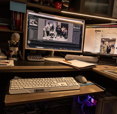 A dual monitor home office setup featuring a white gaming keyboard and professional photo editing software.