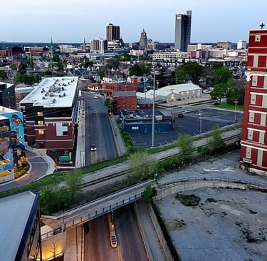 Aerial view of Fort Wayne Indiana downtown skyline with red brick buildings and city streets at dusk.