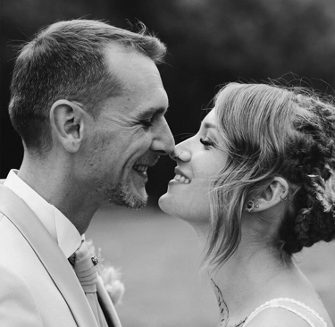 Couple de jeunes mariés qui se sourient mutuellement, le regard plein d'amour.