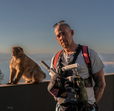 a man with a camera and a monkey sitting on a ledge