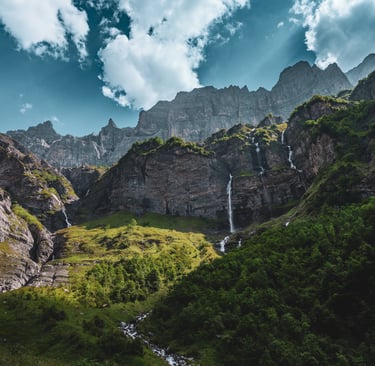 a waterfall in the mountains with a waterfall in the background
