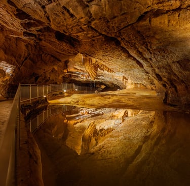 a cave like structure with a pool and a waterfall