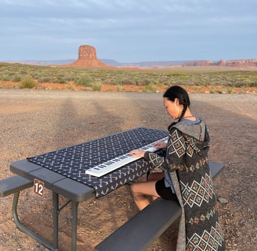 Composer Jen Smith Lanthier playing the keyboard outdoors in Monument Valley