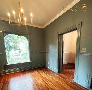 a room with a gold chandelier white ceiling and green walls and trim