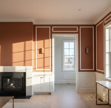 Modern living room with terracotta walls, white picture frame molding, and a sleek fireplace.