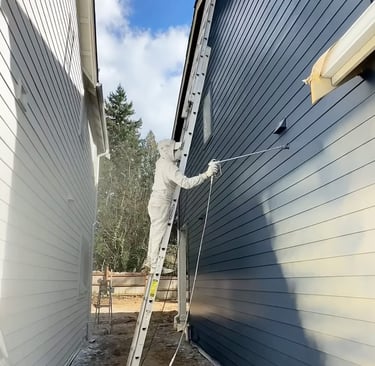 a man is painting a wall of a house in colorado - daeco painiting