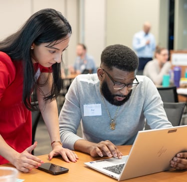 Leadership Austin session, two participants focus intently on a laptop screen