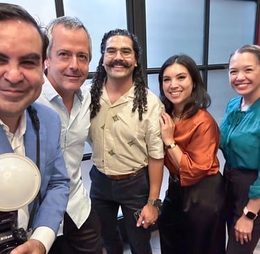 Francisco holds a camera with flash, smiling alongside Hispanic Austin Leadership classmates