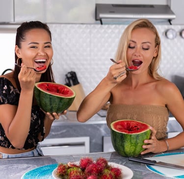 Two women eating watermelon