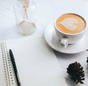 Open Journal page and a cup of coffee on a tabletop