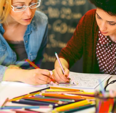 Women enjoying coloring pages from a coloring book