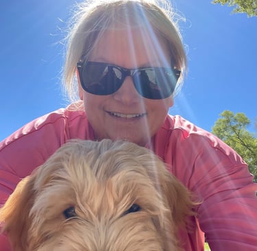 a woman in sunglasses and sunglasses is holding a dog