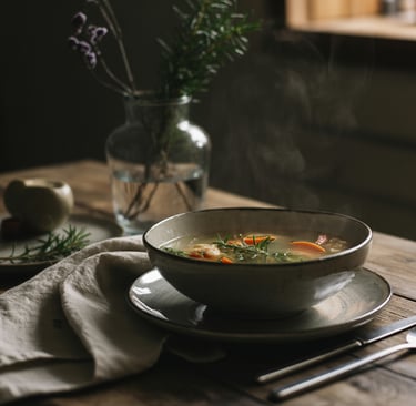 a bowl of soup with a glass of wine