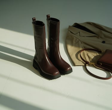 a pair of boots and a purse on a table