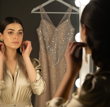 a woman in a gold dress is looking at her reflection in the mirror