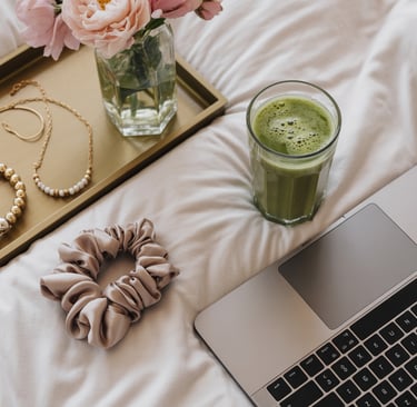 a laptop computer and a cup of coffee on a bed