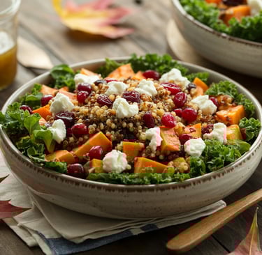a bowl of salad with a glass of wine