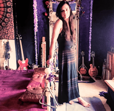 a woman standing in front of a mirror in a bedroom