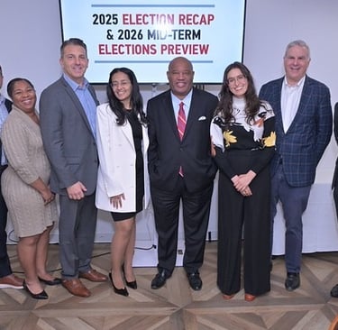 A group of eight professionally dressed people standing together and smiling at a Business Council of Westchester event.