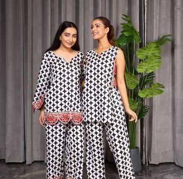 two women standing next to each other in matching patterned outfits