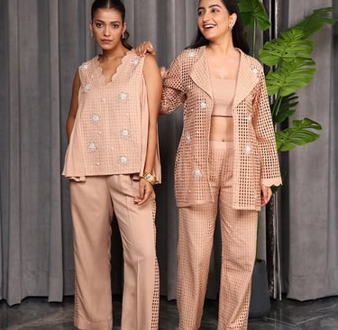 two women in matching pink and beige outfits