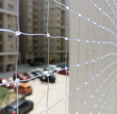 Close-up of the durable net material with sunlight filtering through on a Basavanagudi balcony.