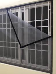 Wide shot of a living room window fitted with a durable mosquito net, showing the clean finish