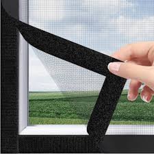 Close-up of a neatly installed mosquito net on a bedroom window with sunlight filtering through