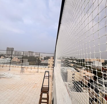 Pigeon netting installed on a rooftop, blending seamlessly with the surroundings.