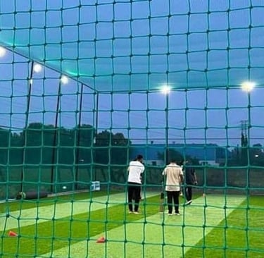 Installation team securing a large sports net at a local Bangalore cricket ground.