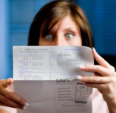 woman shockingly looking at a high water bill