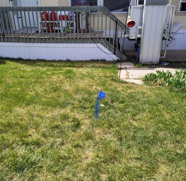 leak marked on the ground with blue paint in front of a mobile home