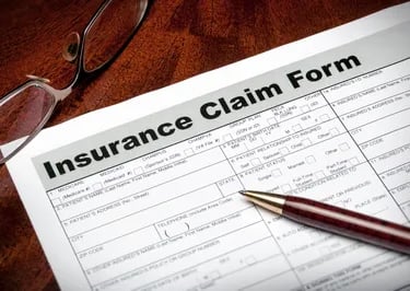 homeowners insurance claim form and a pen