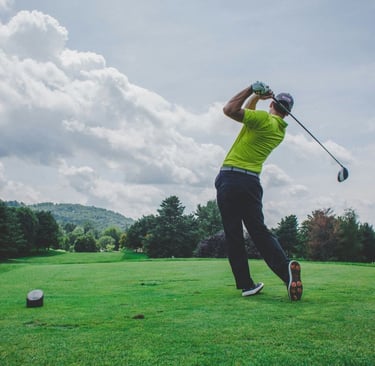 A man hitting a golf ball on a golf fairway