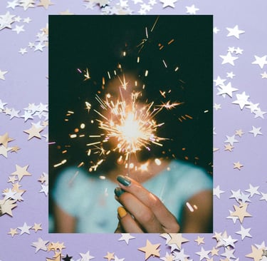 person holding a bright sparkling light surrounded by stars