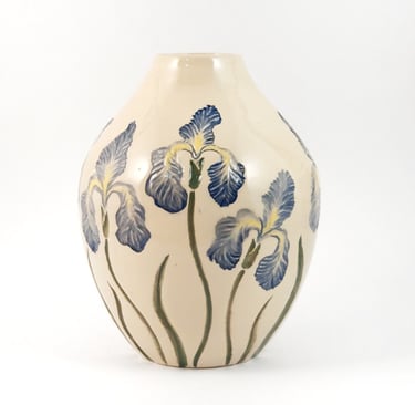 Elegant cream ceramic vase featuring hand-painted blue iris flowers on a white background.