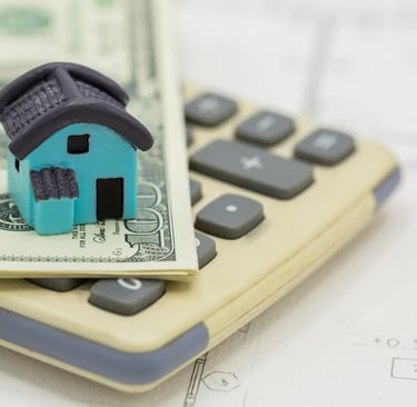 a house model of a house sitting on top of a calculator