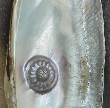 "Side view of 11mm white cultured pearl with radiant sun design–using nucleus technique-For global distribution"