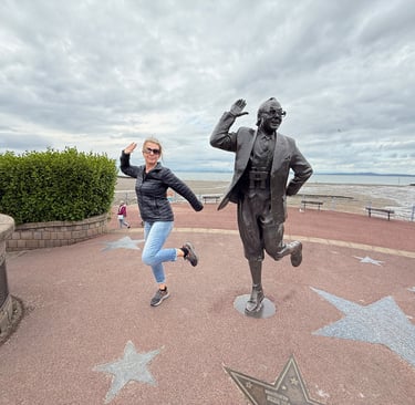 Tracey Billington with a statue of Eric Morecambe in Morecambe, England
