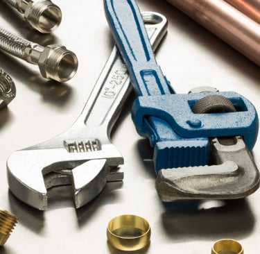 a selection of plumbing tools and pipe fittings