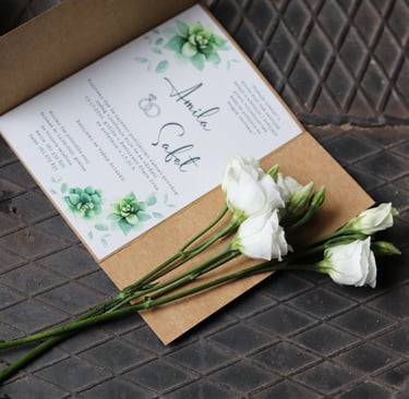 a wedding invitation with flowers on a table