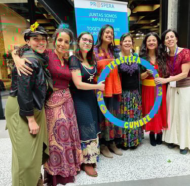 a group of women in colorful dresses holding a large blue circle