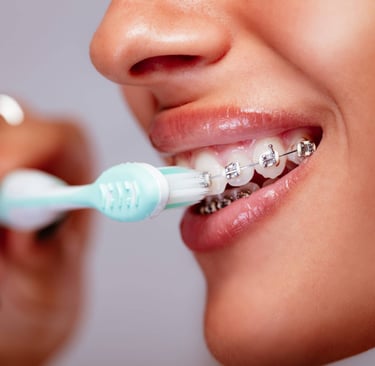 a person brushing teeth with braces