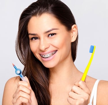 a women wearing bracesand showing toothbrushes in hand