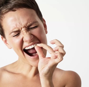 a person trying to remove food stuck between teeth