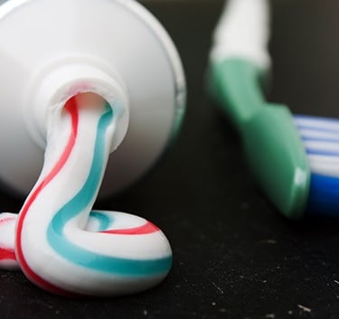 a image showing toothpaste squeezed from tube and a toothbrush