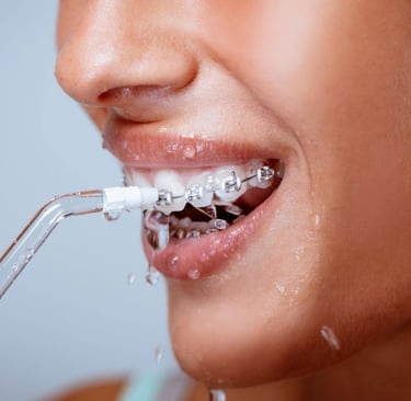 a woman using water flosser in mouth