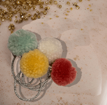 a pom pom decorated hair elastic band