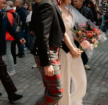 a man and woman in plaidered kilts walking down a street